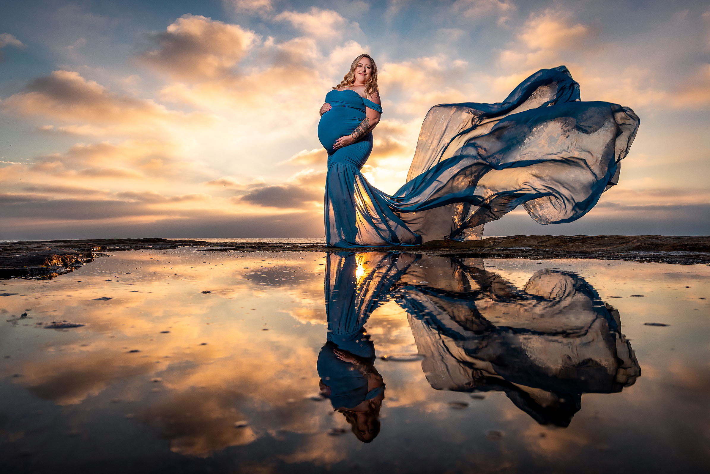 San Diego beach pregnant mother with flowing maternity dress at sunset
