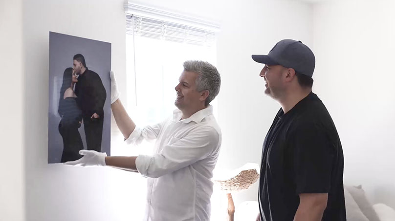 pro photographer help put maternity photo metal print on wall with client in La Jolla