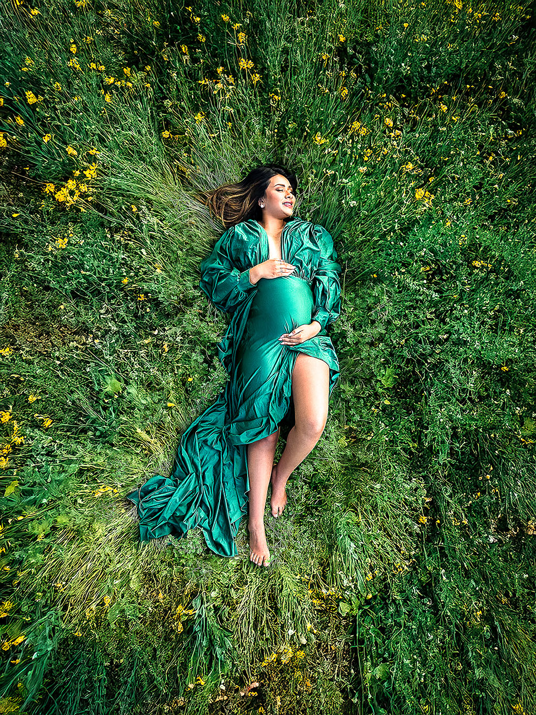 pregnant woman laying in field over head drone photo