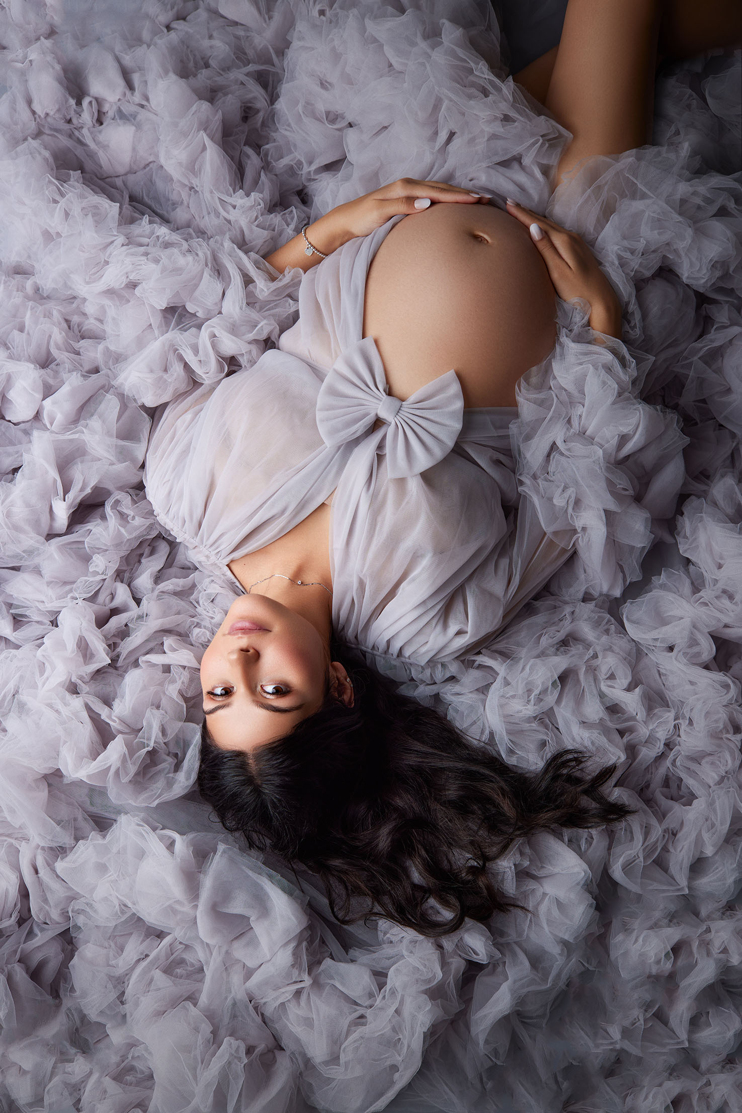 pregnant woman in studio with moody lighting
