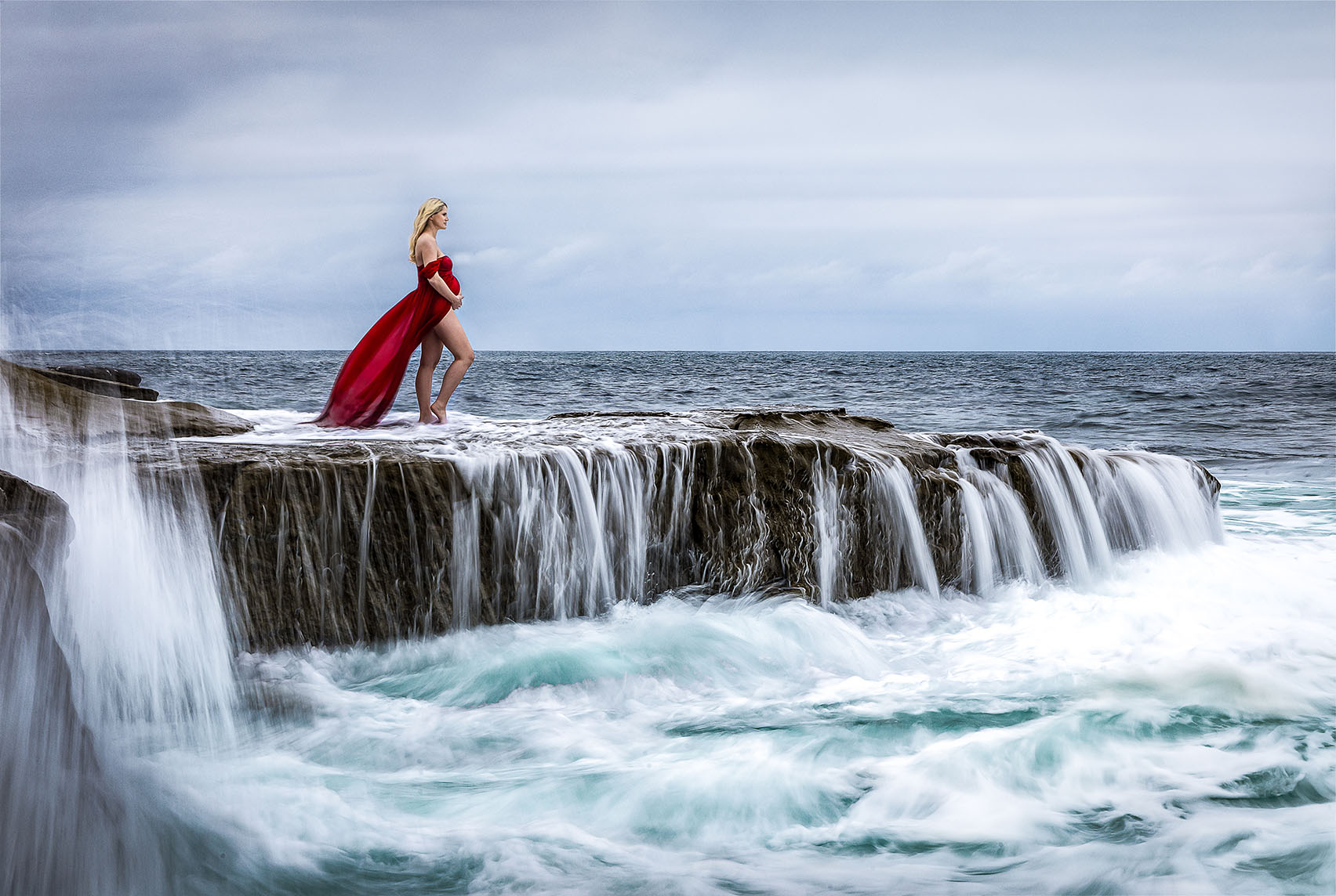 dramatic ocean maternity photo with striking color and waves