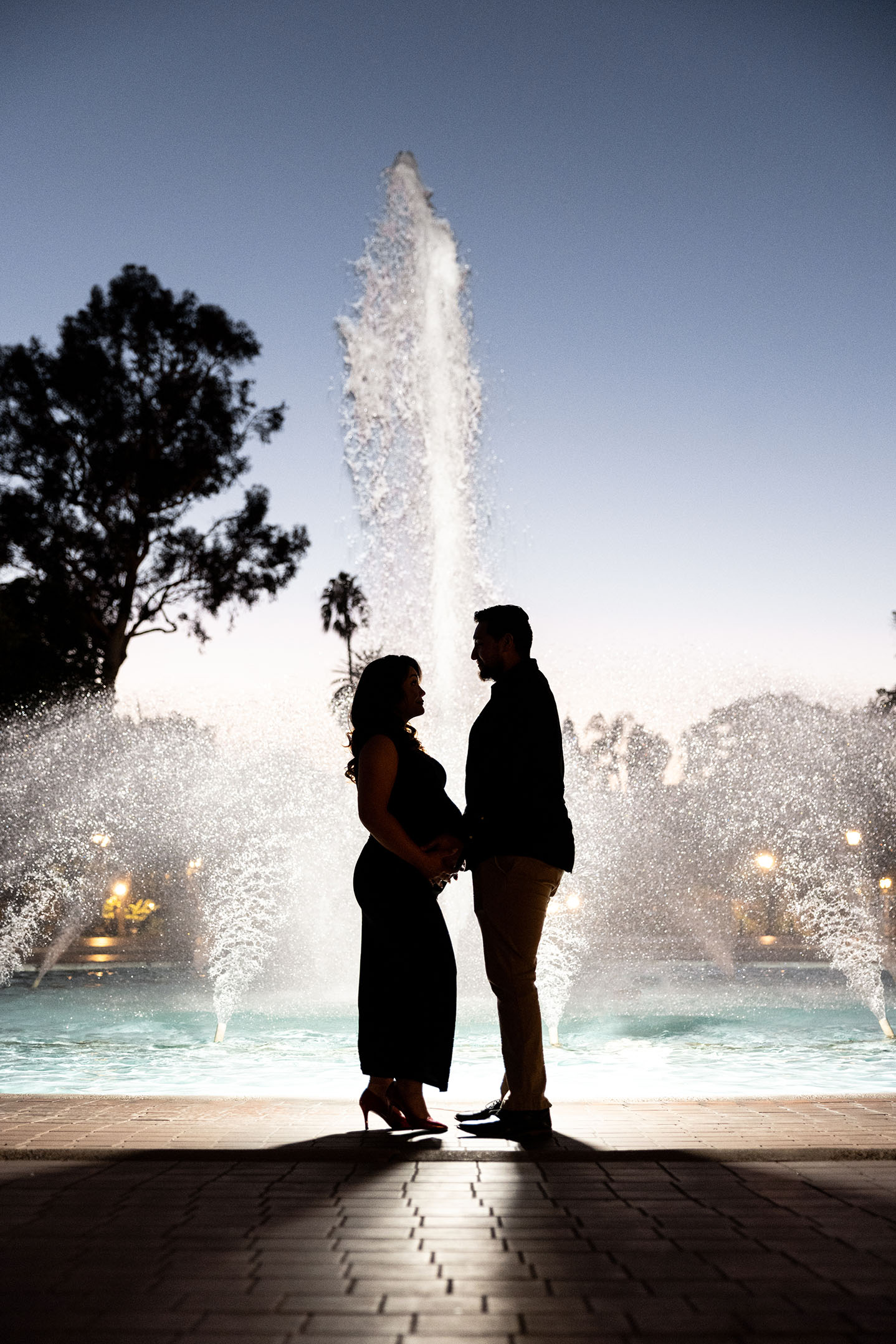 maternity couple in front of fountain at Balboa park in silhouette