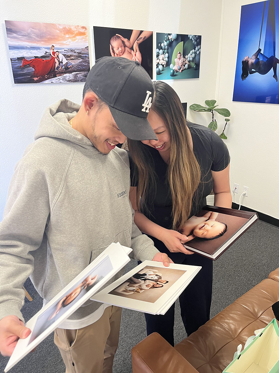 maternity couple looking at new photo prints in studio