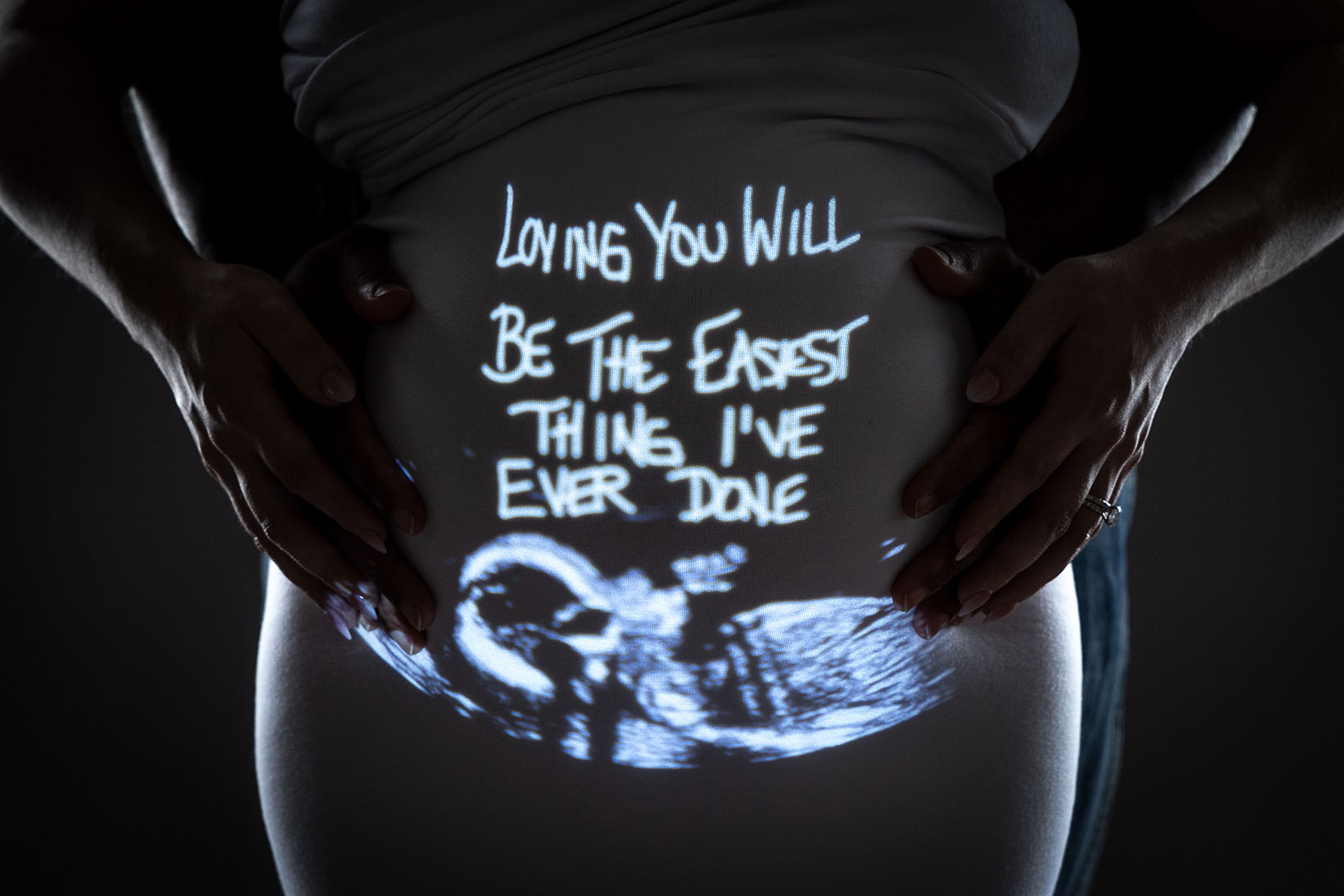 fine art studio photo of pregnant belly with message