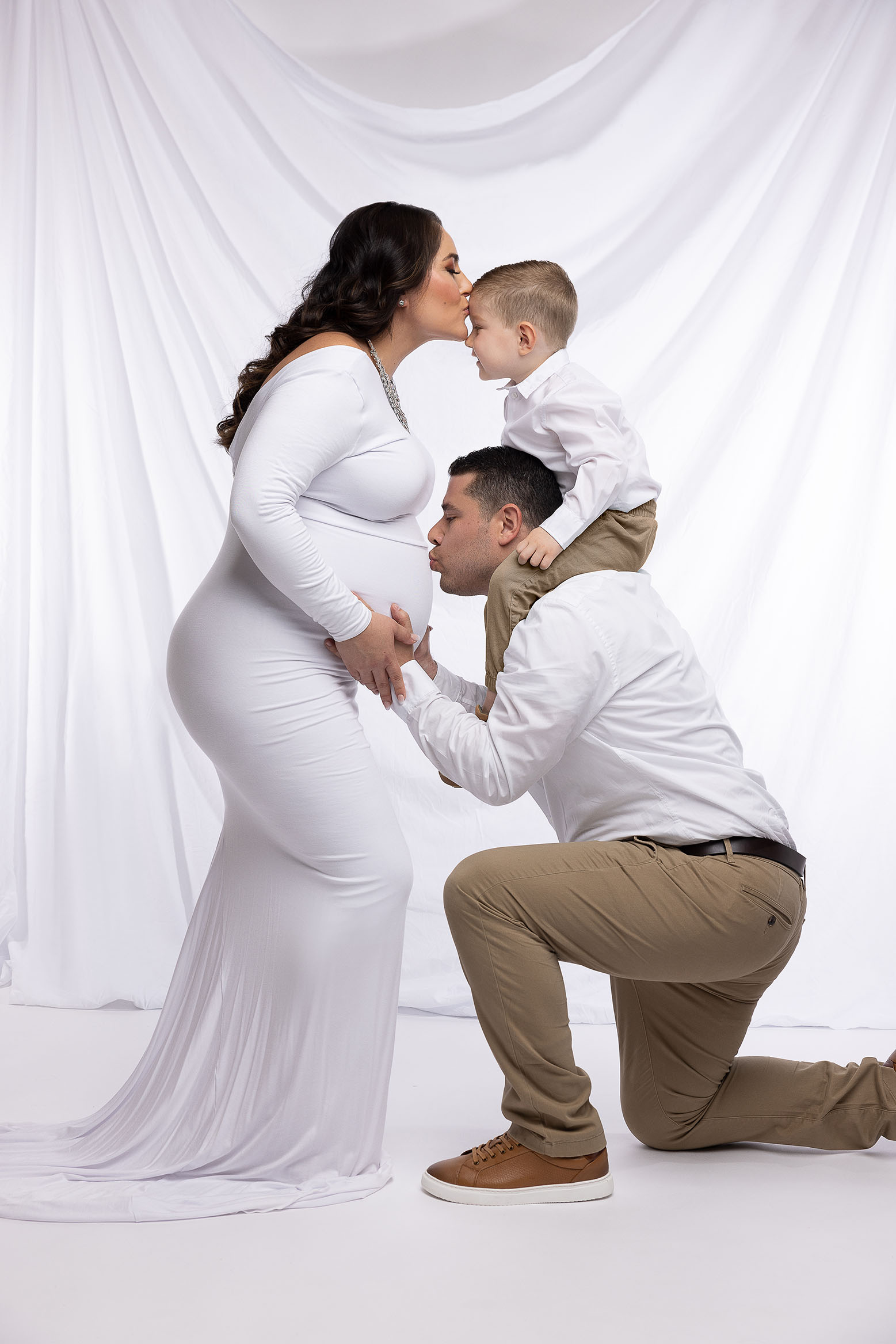 fun posed family photo in studio with pregnancy