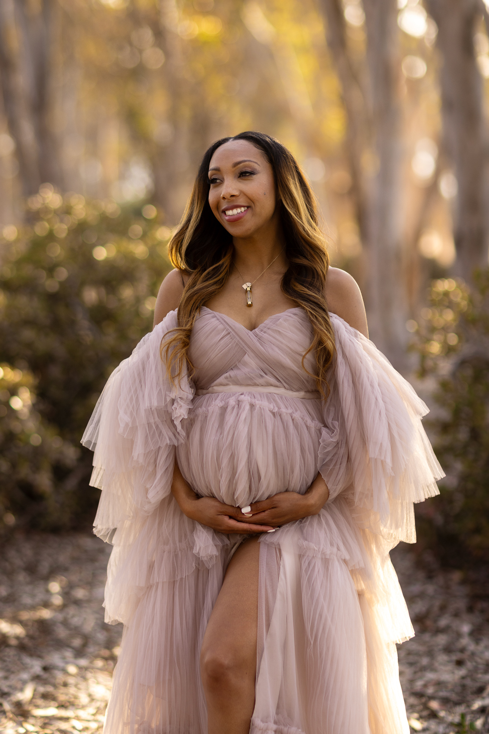 glowing sunny maternity mom in forest with maternity dress